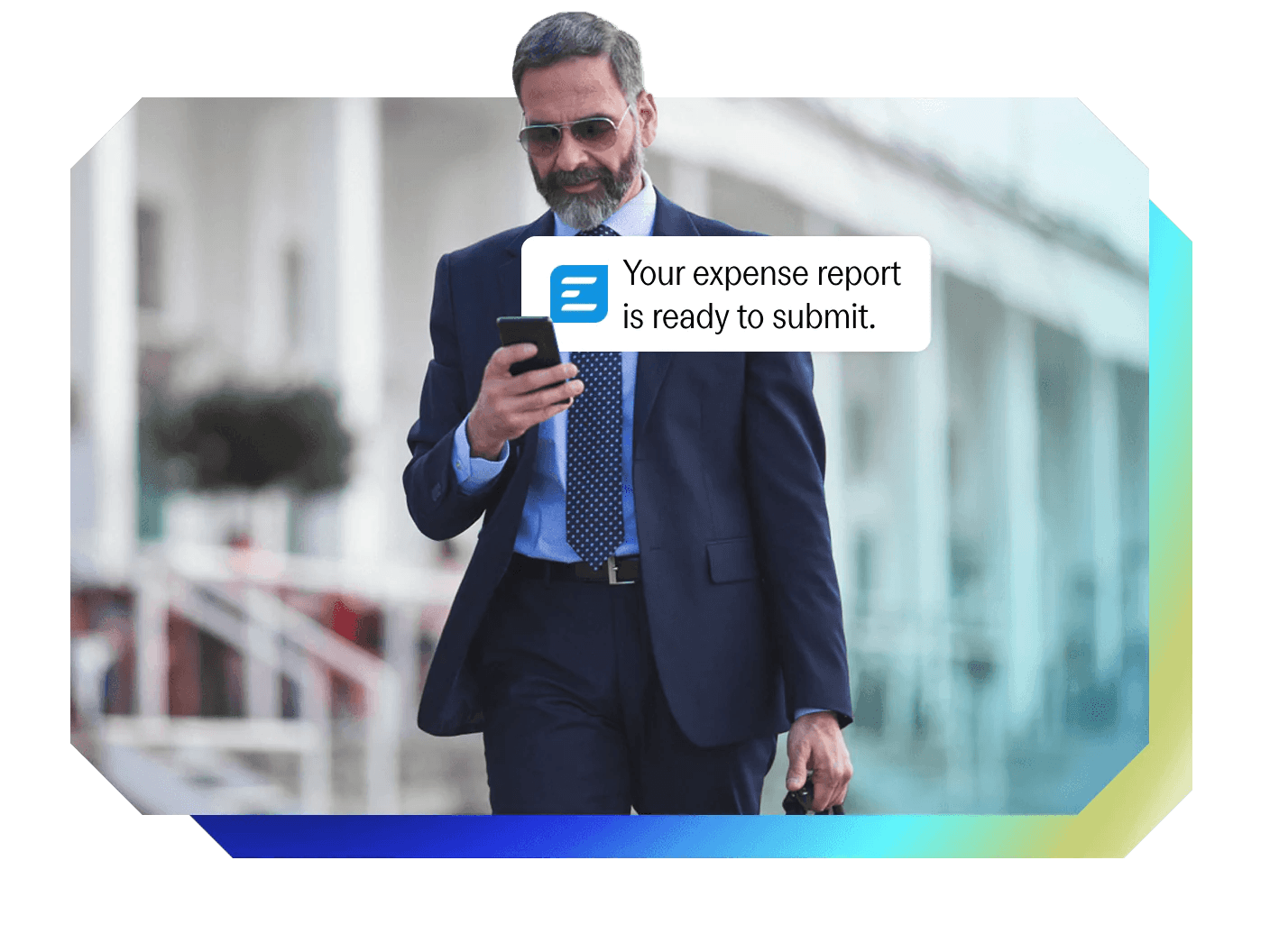a man in a suit looking at his phone with a notification that says your expense report is ready to submit