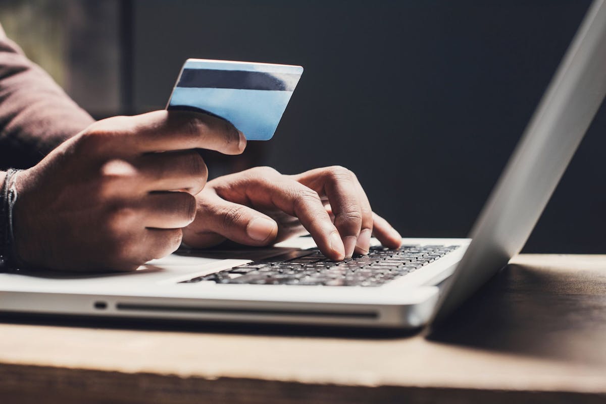 Person using credit card and a laptop