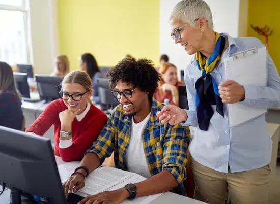 a teacher is teaching a group of students how to use a computer in a classroom .