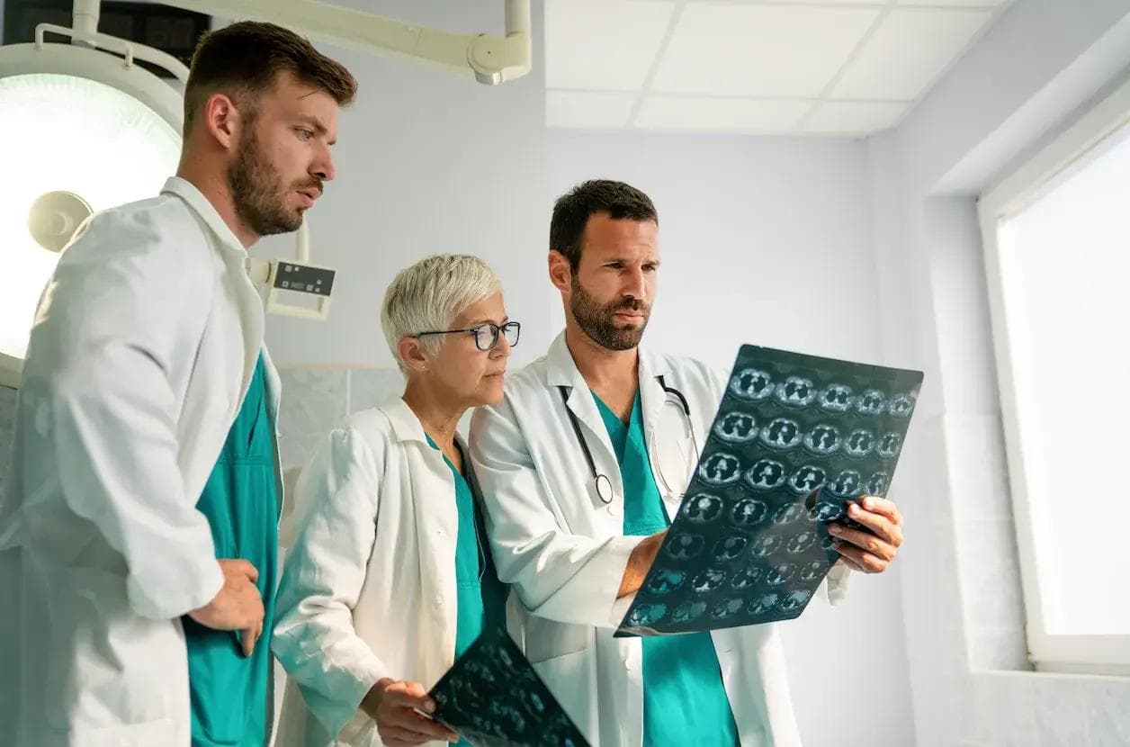 a group of doctors are looking at an x-ray in an operating room .