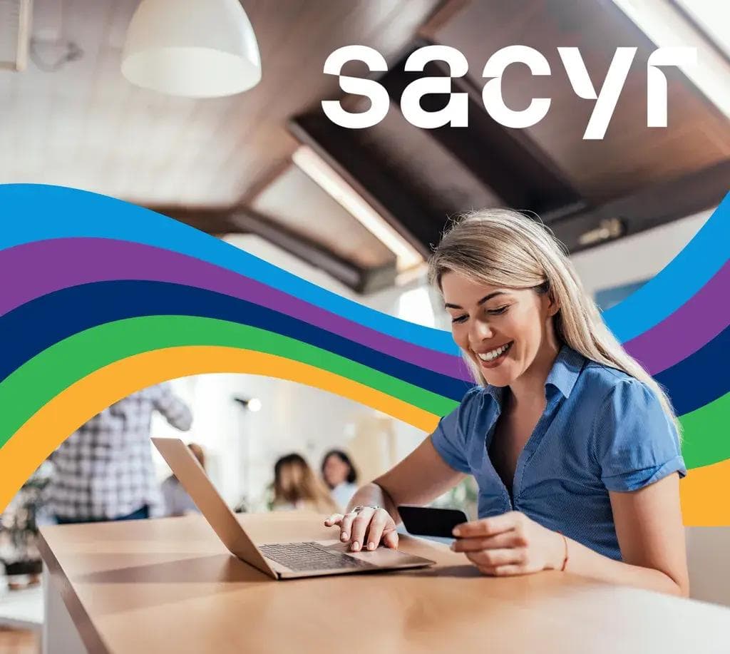 a woman is sitting at a table using a laptop and a credit card .