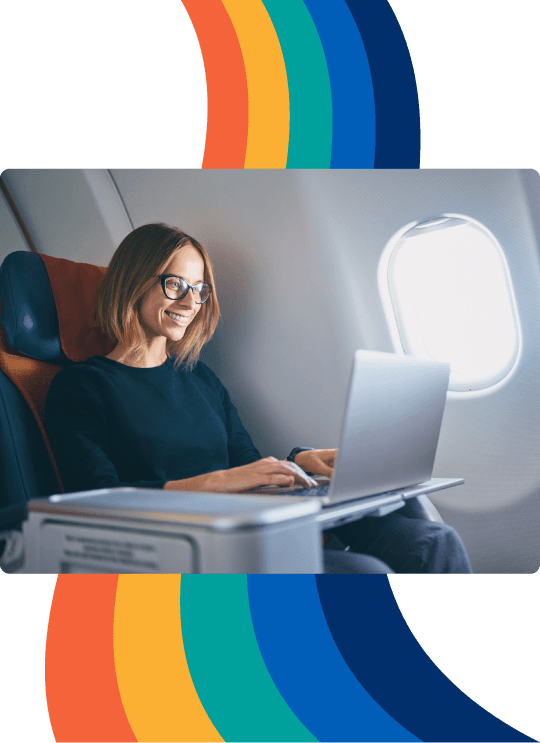 una mujer sentada en un avión utilizando una computadora portátil